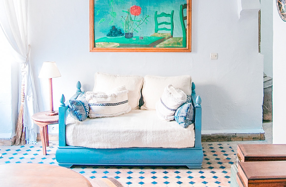 Image of lounge area with two seater sofa with eye-catching painting